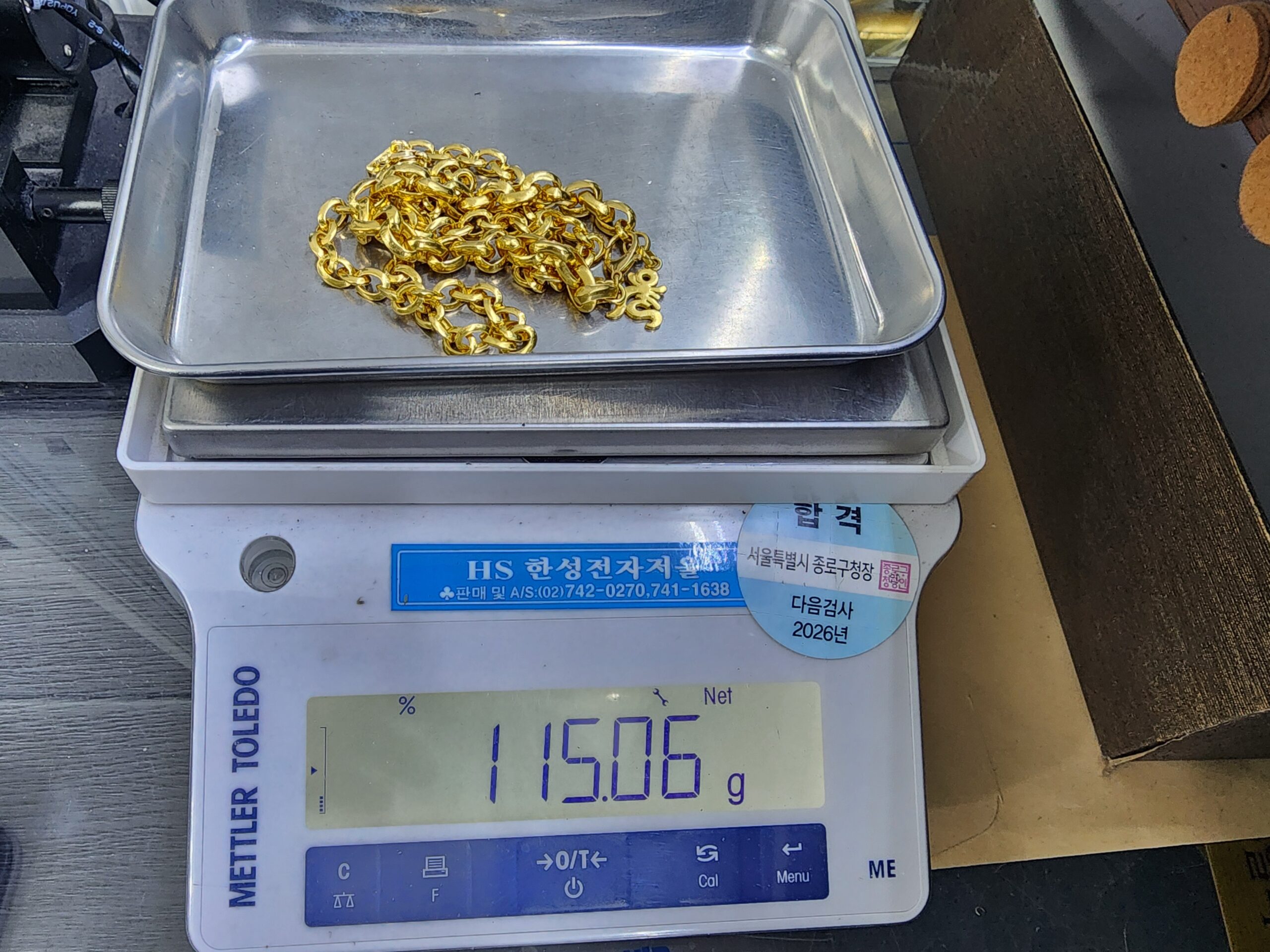 순금 한 돈 금덩이를 저울에 올려 무게를 재는 장면