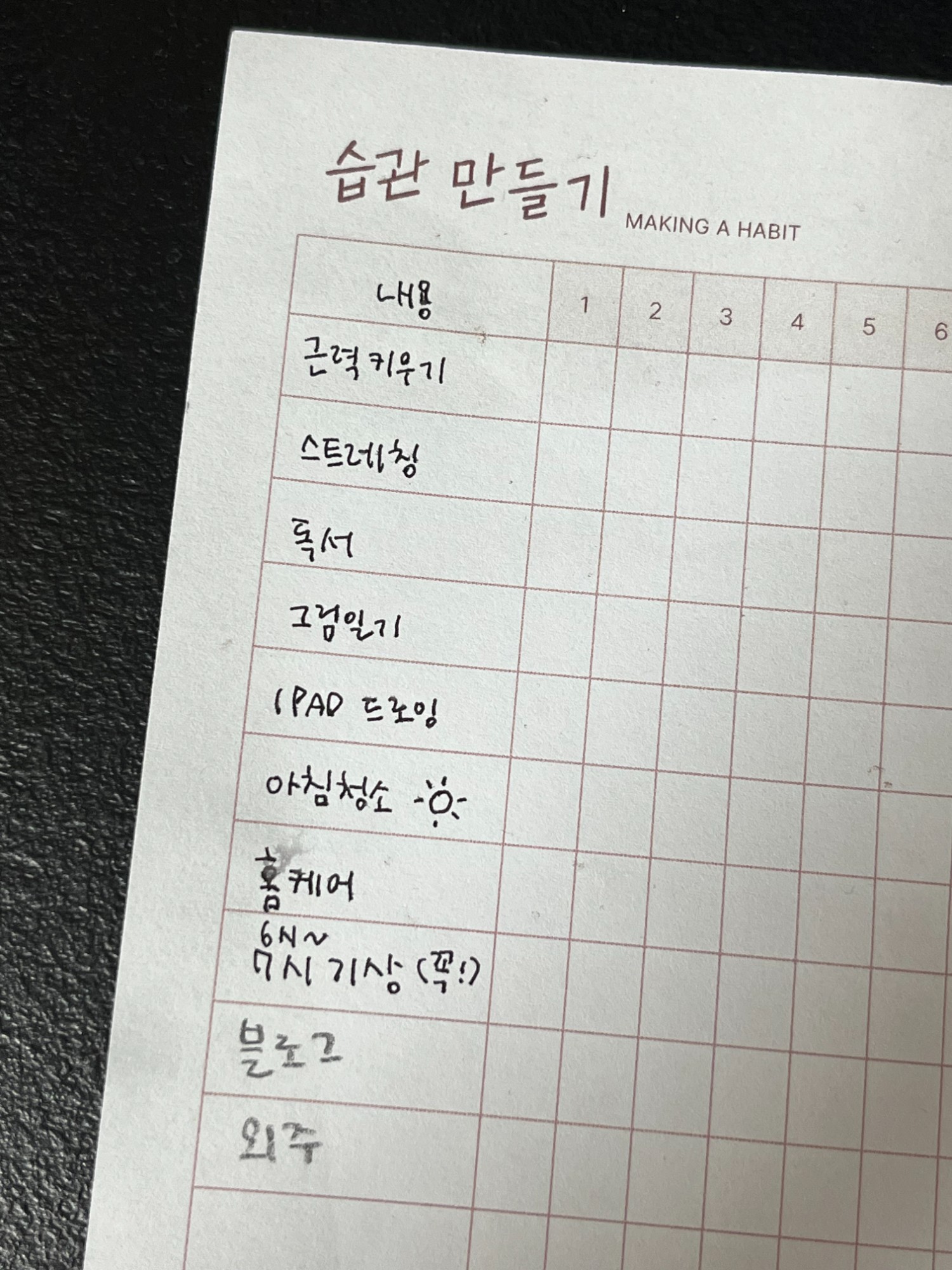 침대 옆 탁자에 놓인 자명종 시계와 물컵