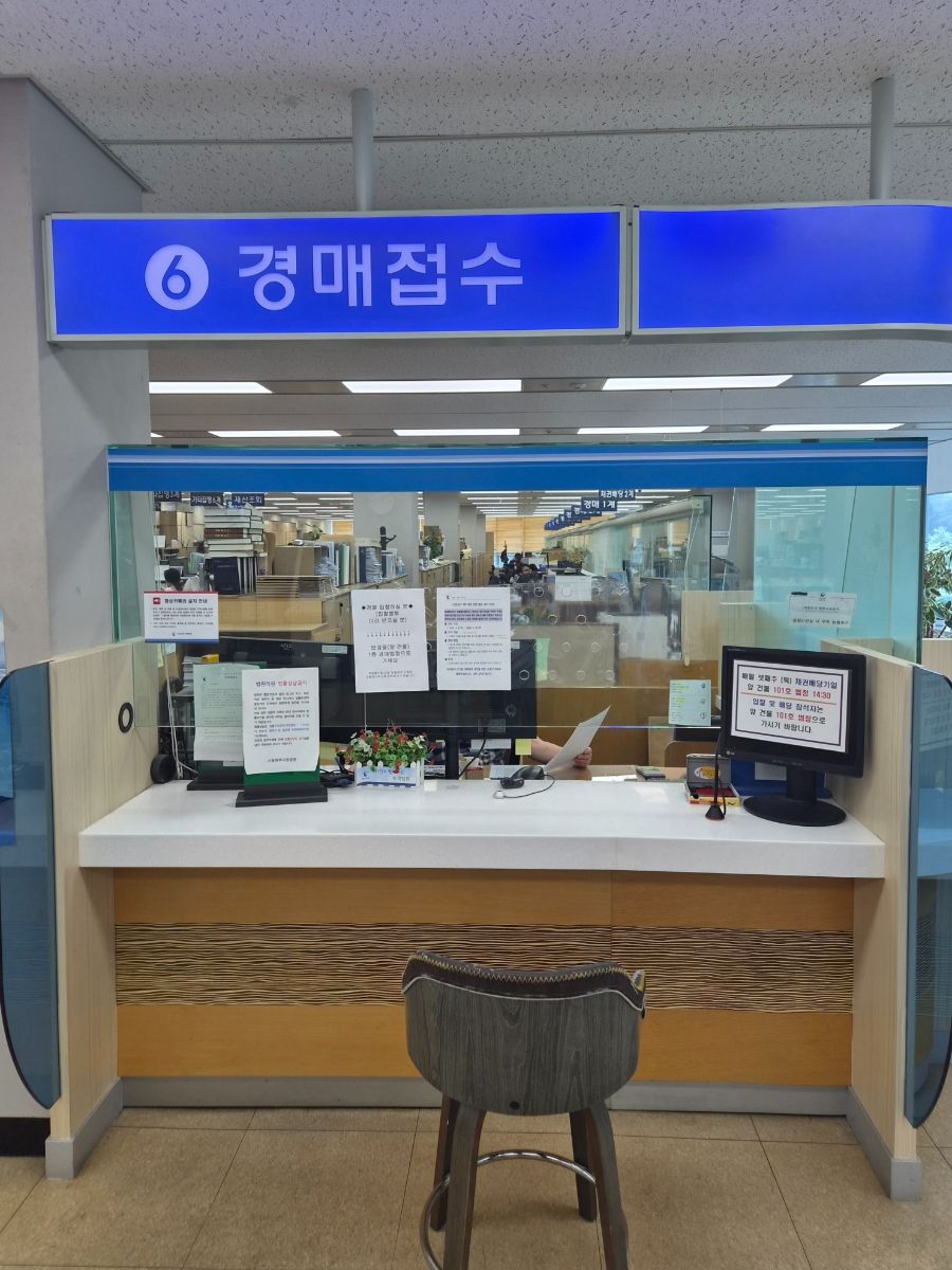 카드 단말기 옆에서 통장 거래내역과 매출 장부를 확인하는 소규모 가게 사장
