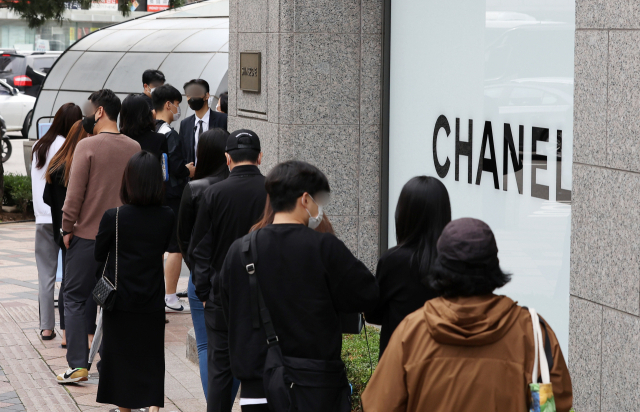 가방 마감(스티치·로고) 클로즈업, 품질 점검하는 손