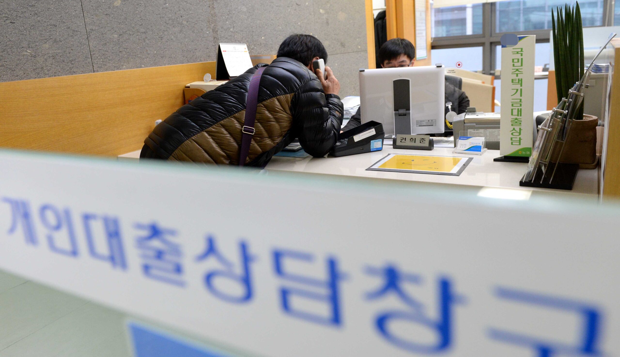 대출 상환 계획표와 계산기를 놓고 비교하는 책상