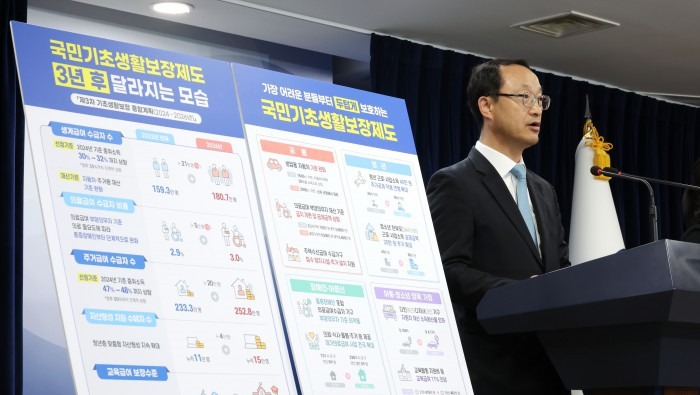 노트북 화면으로 보건복지부 수급자 선정기준 표를 확인하는 모습