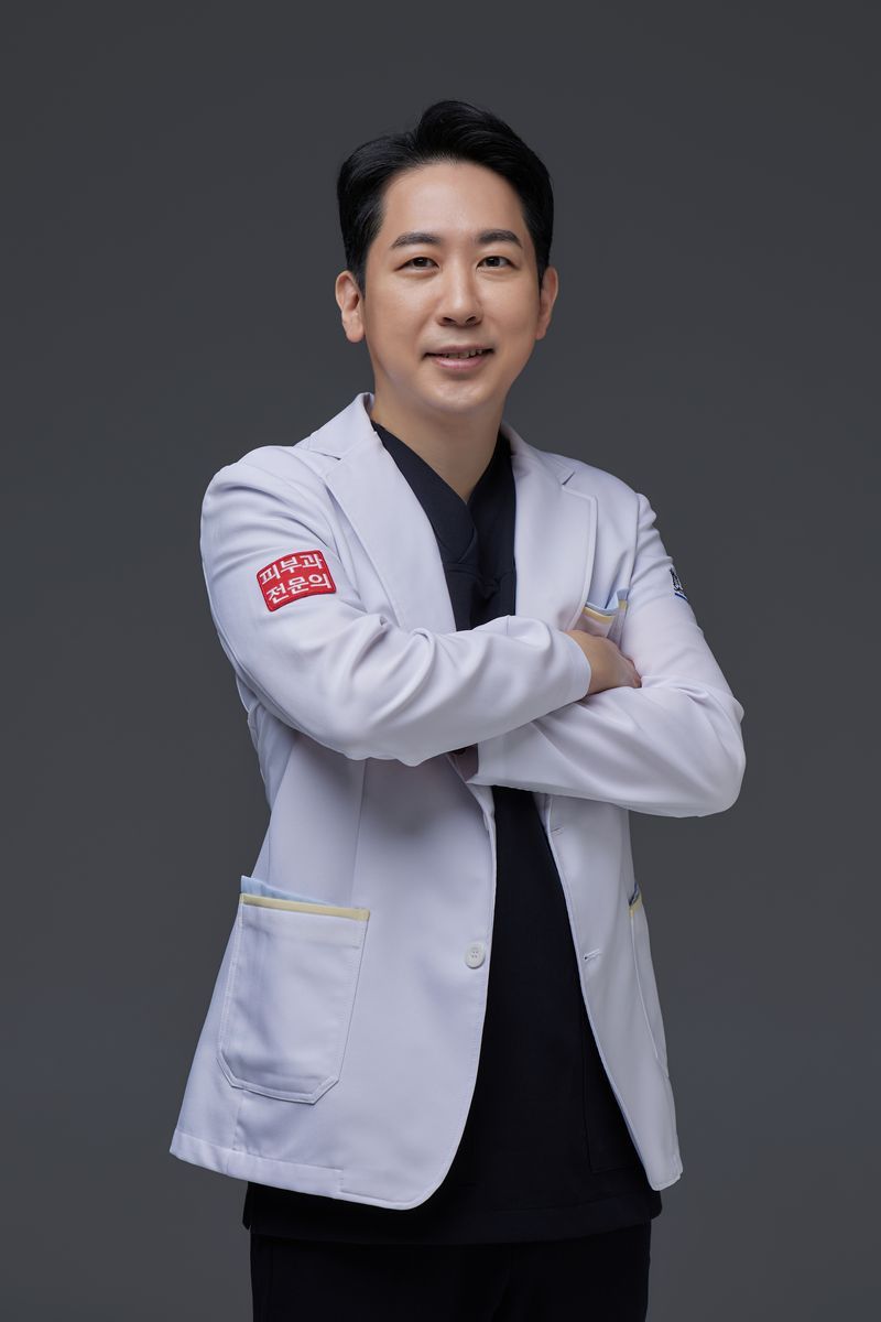 얼굴의 작은 점에 레이저 장비를 대고 제거 시술을 하는 의료진의 손