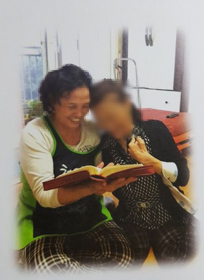 병원 복도에서 휠체어 이용자와 활동지원사가 함께 이동하는 모습