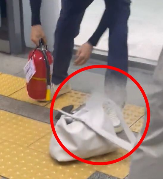 승객이 카운터 직원에게 보조배터리 사진을 보여주며 설명하는 장면