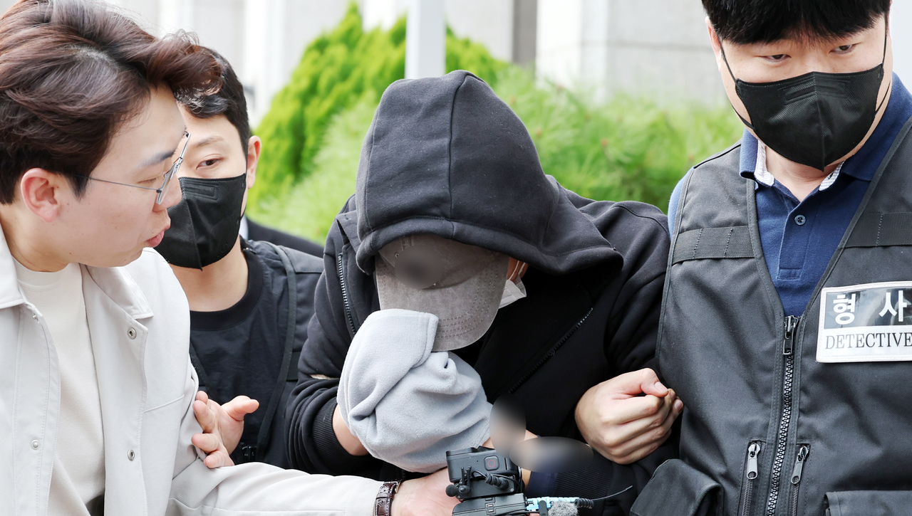 경찰 신상공개심의위원회 회의실에서 위원들이 자료를 보며 논의하는 장면