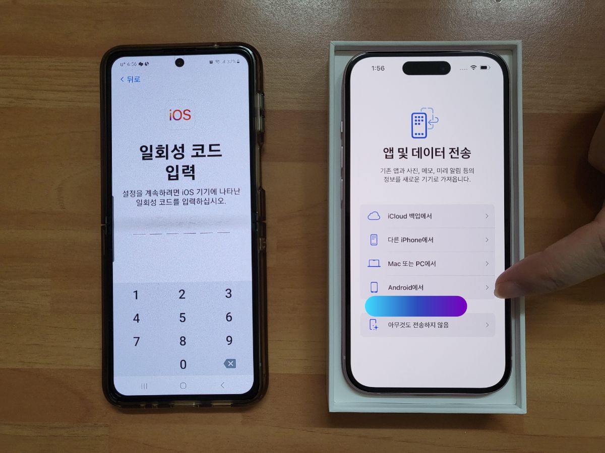 새 아이폰과 이전 아이폰을 나란히 놓고 화면을 확인하는 사람의 손