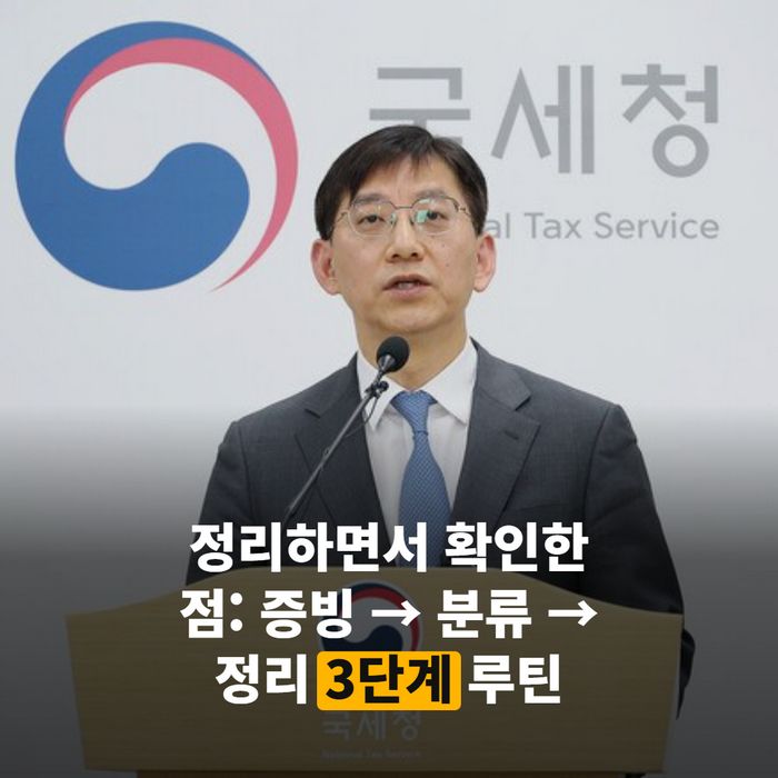 월별로 영수증을 분류해 파일 폴더에 꽂아 정리하는 손